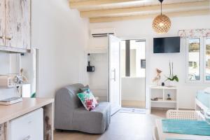 a living room with a chair and a tv at Irene's Studio in Mikonos
