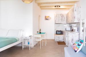 a bedroom with a bed and a desk and a table at Irene's Studio in Mikonos