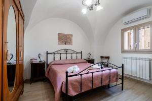 a bedroom with a bed with a pink blanket at Casa vacanza Sotto La Lizza in Alezio