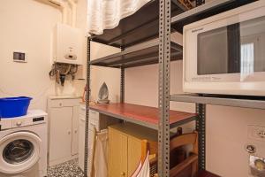 a kitchen with a microwave and a washer and dryer at Miriam e Carlo in Moneglia