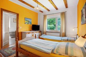 two beds in a room with yellow walls at Fereienhaus Usedom Achterland in Dewichow