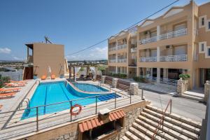 a building with a swimming pool next to a building at Sunrise Apartments Crete in Sfakaki