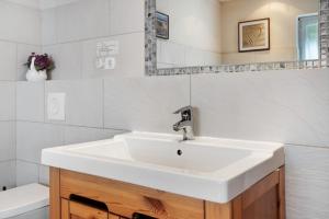 a white bathroom with a sink and a toilet at Fereienhaus Usedom Achterland in Dewichow +17 photos