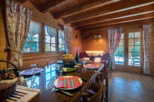 a dining room with a table and chairs and windows at Chalet mitoyen 4 personnes in Alex