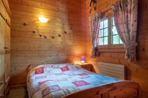 a bedroom with a bed in a log cabin at Chalet mitoyen 4 personnes in Alex