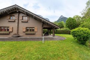 a house with a thatched roof and a yard at Chalet mitoyen 4 personnes in Alex