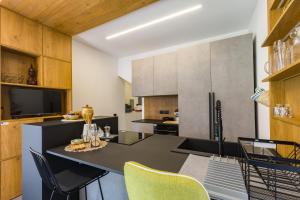 a kitchen with a table and chairs in a room at Gatto Matto in Brolo +31 photos