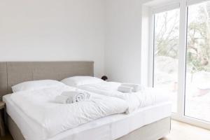 a white bed with white sheets and a window at Koje in Böhl
