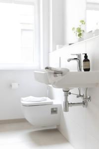 a white bathroom with a sink and a toilet at Koje in Böhl