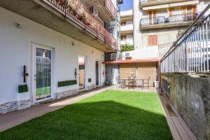 a courtyard with green grass in a building at Gatto Matto in Brolo