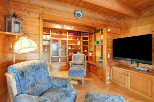 a living room with a tv and two chairs at Ferienhaus Sankt Peter in Wittenschwand