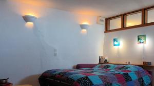 a bedroom with a bed and two lights on the wall at La Clé des Sens in Castelnau-Pégayrols