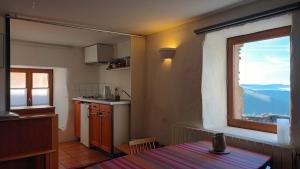 a kitchen with a window and a table in a room at La Clé des Sens in Castelnau-Pégayrols