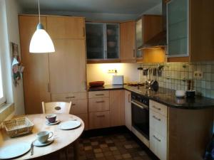 a kitchen with wooden cabinets and a table with plates on it at Ludwig im Künstlerhaus in Langmühle