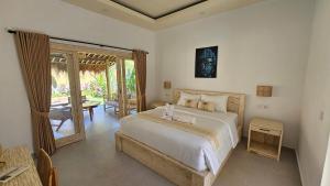 a bedroom with a large bed and a patio at Amed Saïta Villas in Amed
