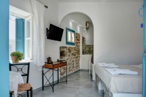 a small room with two beds and a bathroom at Politimis Studio N5 in Amorgos