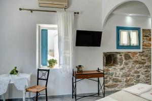 a room with a bed and a table and a chair at Politimis Studio N5 in Amorgos