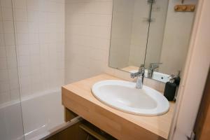 a bathroom with a sink and a mirror and a tub at Appartemment 6 couchages Risoul in Risoul +12 photos