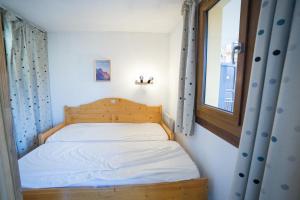 a small bed in a room with a window at Appartemment 6 couchages Risoul in Risoul