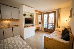 a small room with a bed and a kitchen at Appartemment 6 couchages Risoul in Risoul