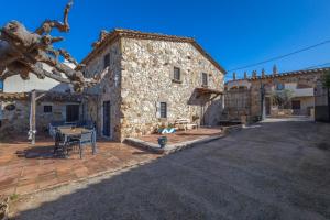 a large stone building with a table in front of it at Can Tarana in Santa Cristina d'Aro