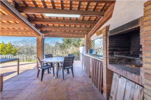 a patio with a table and chairs and a fireplace at Can Tarana in Santa Cristina d'Aro