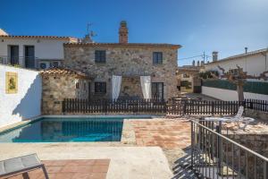 a villa with a swimming pool in front of a house at Can Tarana in Santa Cristina d'Aro