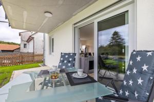 a glass table and chairs on a patio at Ferienwohnung "Haus Kellenburg" in Albstadt