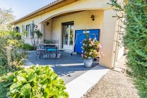 a house with a blue door and a patio at Petit coin de paradis Périgourdin in Montrem