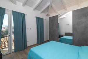 a bedroom with a bed and a large window at Attico con vista mare a Budoni in Budoni