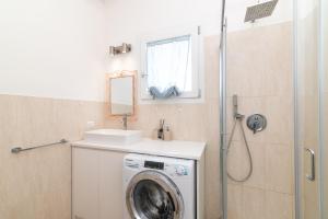 a bathroom with a washing machine and a sink at Attico con vista mare a Budoni in Budoni
