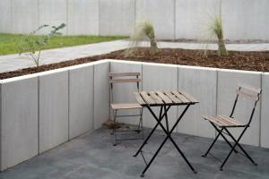 two chairs and a table next to a wall at Meerrettichnest in Appenweier