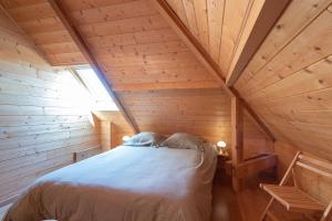 ein Schlafzimmer in einer Blockhütte mit einem Bett darin in der Unterkunft Maison Zen dans les Pyrénées in Coarraze