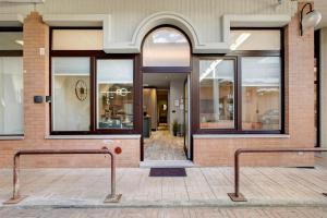 a store front with two benches in front of a building at Maison Bijoux Aosta in Aosta