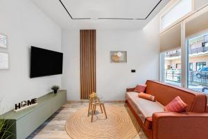 a living room with a couch and a tv at Maison Bijoux Aosta in Aosta