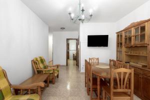a dining room with a table and chairs and a tv at Piso Leoncio Breña Alta in Breña Alta