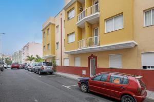 a red car parked in a parking lot next to a building at Piso Leoncio Breña Alta in Breña Alta