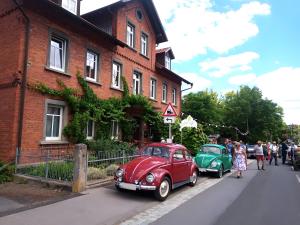 two old cars parked in front of a building at Ferienwohnung Zur Eisenbahn in Fladungen