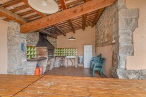 a kitchen and living room with a stone wall at Masoveria De Vilanova in Sagás