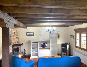 a living room with a blue couch and a table at Los Avellanos Casa 1 in Celis