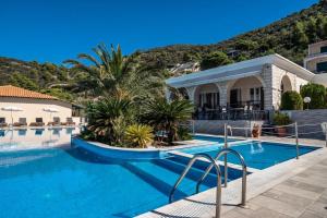 a swimming pool in front of a villa at Sunset Premium Studio 13 in Lefkada