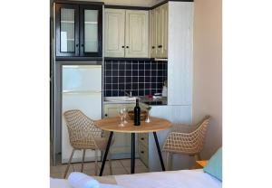 a small kitchen with a table with wine glasses on it at Sunset Premium Studio 13 in Lefkada