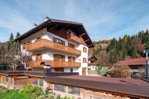 a building with wooden balconies on top of it at Appartamenti Adriano Minotto in Falcade