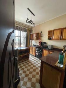 a kitchen with a refrigerator and a checkered floor at Alz Haven in Jinja