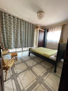 a bedroom with a bed and a window and a chair at Alz Haven in Jinja