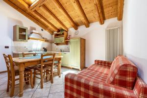 a kitchen and dining room with a table and a couch at Agritur Piazera Attico in Ronzo Chienis