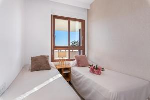 two beds in a room with a window at Michael in Torre de la Horadada +20 photos