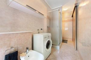 a bathroom with a washing machine and a sink at Loft bellavista in San Fedele Superiore +16 photos