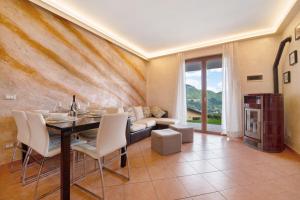 a dining room with a table and a couch at Loft bellavista in San Fedele Superiore