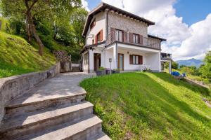a white house on a hill with a pathway at Loft bellavista in San Fedele Superiore